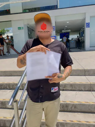 Trabajador con su notificación laboral en las escaleras del centro de justicia laboral de Jalisco