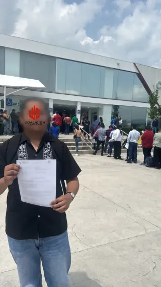 Trabajador atendido por Coalición Montaño con su documento afuera de Ciudad Laboral, en Guadalajara
