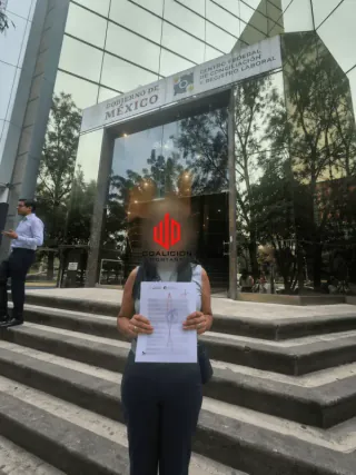 Persona atendida en su asunto laboral sosteniendo su documento afuera de los tribunales de Jalisco